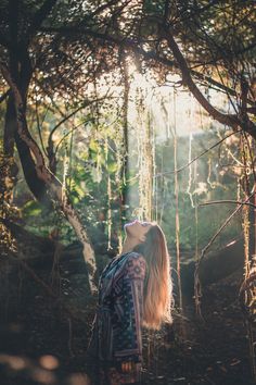 a woman standing in the woods with her eyes closed