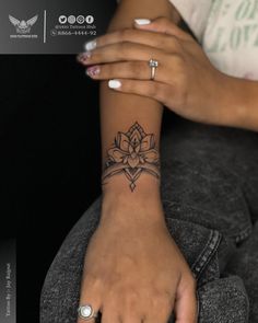 a woman's hand with a tattoo on it and a ring in the middle