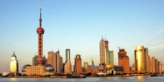 a city skyline with tall buildings in the foreground and a body of water below