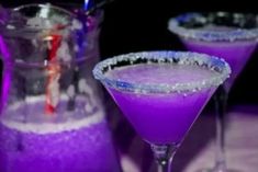 two glasses filled with purple liquid on top of a table