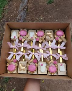 a box filled with lots of pink and gold desserts