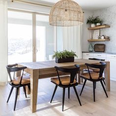 a dining room table with chairs and a potted plant on top of the table