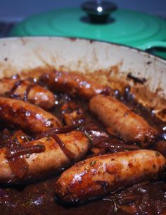 several sausages are cooked in a brown gravy