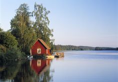 a red house sitting on top of a lake