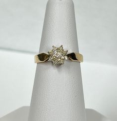 This ring is made with 14k gold, and has the 14k stamped inside the ring. Vintage with an unknown age, and is from an estate sale. It has one round brilliant cut diamond as the centre stone, and 16 single cut diamonds (all of them are natural diamonds) around the centre stone, all in white gold claw settings. Carat weight: 0.20 ct  Clarity: VS-SI Colour: G-H Cut: Good Item weight:  2.76 grams  Can be re-sized upon request, message our shop after purchase. This will delay the shipment date. The a 14k Gold Cluster Diamond Ring, 14k Gold Cluster Diamond Ring With Prong Setting, Yellow Gold Diamond Cluster Ring For Anniversary, Cluster Yellow Gold Diamond Ring With Prong Setting, Yellow Gold Cluster Diamond Ring For Anniversary, Yellow Gold Diamond Ring With Brilliant Cut Cluster, Yellow Gold Cluster Diamond Ring With Prong Setting, Anniversary Yellow Gold Cluster Diamond Ring, 14k Gold Cluster Diamond Ring In Diamond White