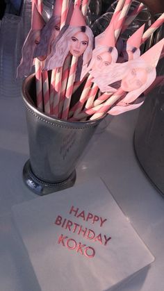 there are many pink and white birthday candles in a silver cup with the words happy birthday koko on it