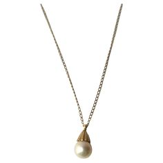 A very beautiful white cultured pearl on a 14-karat yellow gold necklace, circa mid-20th century. Pearl is very beautiful with a high luster. Pearl has a 14-karat yellow gold crown-like design at top attached to 14-karat yellow gold necklace. A beautiful piece to wear alone or stack with other necklaces (as demonstrated.) Very good condition as shown in images. No issues. Dimensions: pearl pendant is .50" long x .25" width. Necklace, from end to end, measures 19.25" long. For gold choker necklace shown, search 1stDibs ref. #: LU4068223052022 For Italian heart necklace search ref. #: LU4068222740332 Vintage Pendant Necklace, Pearl Necklace Vintage, Turquoise Pendant Necklace, Solitaire Pendant Necklace, Yellow Gold Necklace, Cultured Pearl Necklace, Coral And Gold, Gold Choker Necklace, White Gold Necklaces