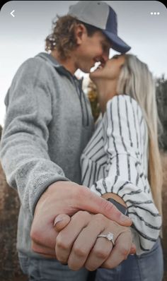 a man and woman holding hands while standing next to each other