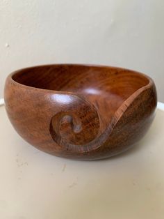 a wooden bowl sitting on top of a white table