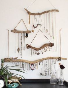 there is a wall hanging made out of branches and jewelry on the shelf next to it