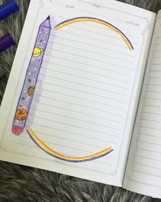 an open notebook with pencils on top of it