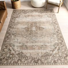 a large area rug with an ornate design on the floor in a living room setting