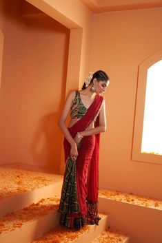 Introducing our striking Red Lehriya Drape Saree with Artsilk Bandhani and Shell detailing, accompanied by a Green Print Bandhani Blouse adorned with Shells and Fringes – a captivating ensemble that seamlessly merges traditional aesthetics with contemporary charm. Blouse On Bandhani Saree, Contemporary Saree Look, Red Saree Design, Lehariya Saree Blouse Design, Lehriya Saree Blouse Designs, Blouse Designs For Bandhani Sarees, Red Saree Green Blouse, Bandhani Blouse Design, Bandhani Saree Blouse Design