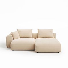 a white couch sitting on top of a white floor next to pillows in the shape of a recliner