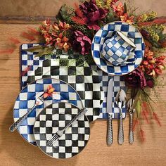 the table is set with checkered plates and silverware, which are decorated with flowers