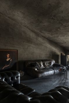 a living room filled with furniture and a painting on the wall next to a couch