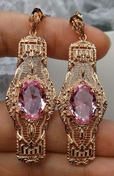 "Simulated Pink Topaz Earrings Castle Oval Design#E4 Custom Made Inspired by the Art Deco movement of the early 1900s, I now offer these lovely Antique reproduction earrings in Rose Gold sterling silver. Each stunning 5ct flawless Man-made/Simulated Pink Topaz gemstone is 14mm long (just over 9/16th\") and 10mm in width (3/8\"). The pink topaz gemstones have perfect color and clarity. The earrings are 2 1/2th inches long. Notice the beautiful design of the Deco filigree setting. These earrings w Rose Gold Oval Earrings For Wedding, Pink Earrings With Intricate Design For Gift, Rose Gold Filigree Dangle Jewelry, Exquisite Oval Pink Jewelry, Oval Pink Gold Jewelry For Anniversary, Oval Pink Gold Jewelry For Anniversaries, Pink Jewelry With Intricate Design For Anniversary, Formal Oval Jewelry With Plating, Rose Gold Oval Earrings For Anniversary