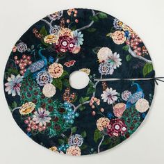 a circular piece of cloth with flowers and birds on it