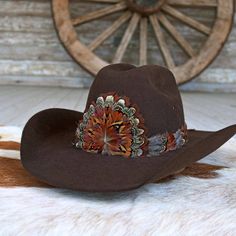 The Rowan Western Feather Hat Band, Short, is specially crafted for smaller-sized hats (6 7/8 and under) and kids' hats. Made from 100% feather, it has an approximate length of 53 cm (excluding leather ties) and a width of 2 cm. The crest measures 4" W x 3.25" H, adding a distinctive and elegant touch to the design. Adjustable with leather ties, this hat band ensures a secure fit while providing a stylish western accent for smaller hats. Brown Southern Style Hat For Rodeo, Brown Curved Brim Top Hat For Ranch, Adjustable Winter Hat With Feather Trim, Brown Felt Hat With Short Brim For Rodeo, Western Felt Hat With Feathers And Curved Brim, Western Style Felt Hat With Curved Brim And Feathers, Brown Short Brim Felt Hat For Rodeo, Adjustable Felt Hat With Feathers For Winter, Brown Western Hat For Fall