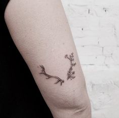 a woman's arm with a small flower tattoo on it