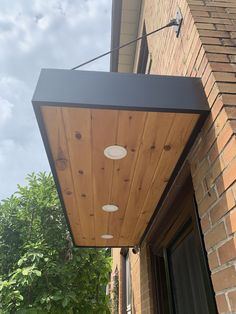 the outside of a brick building with an overhead light fixture on it's side