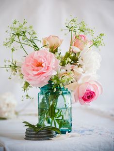 a vase filled with pink and white flowers on top of a table next to an instagram page