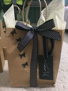 two brown paper bags with black and white bows