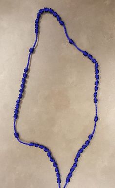 a blue beaded necklace on a white surface