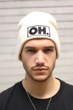 a young man wearing a white hat with the word oh written on it and a chain around his neck