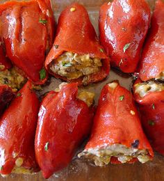 several stuffed red peppers on a cutting board