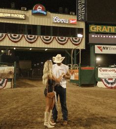 a man and woman are standing in the dirt