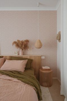 a bed room with a neatly made bed next to a night stand and side table