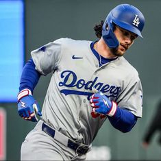 a dodgers baseball player running with the ball in his hand and wearing a blue helmet