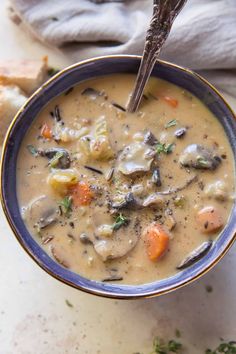 a blue bowl filled with soup next to bread