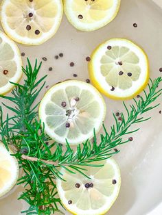 lemons and rosemary are arranged on a plate