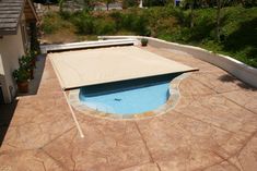 an above ground pool with a tan cover on it's edge and some trees in the background