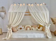 a canopy bed with curtains and stuffed animals