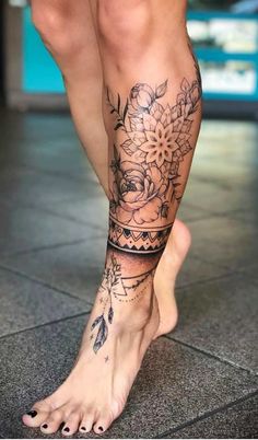 a woman's legs with tattoos and flowers on them