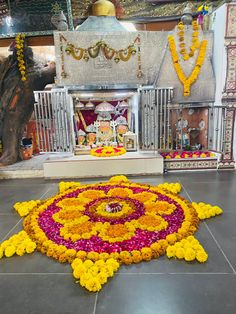 a large flower arrangement on the ground in front of a shrine