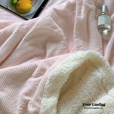 a pink blanket and some fruit on a table