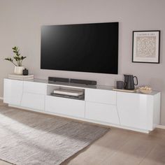 a flat screen tv sitting on top of a white entertainment center in a living room