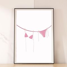 there are three pink hearts hanging from a line on the wall next to a vase