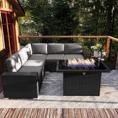 a couch and table on a deck with trees in the background