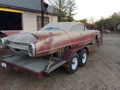 an old car is being towed by a trailer