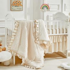 a baby crib with a blanket and stuffed animals on the floor next to it