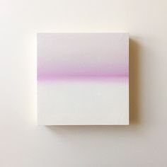 a white and pink painting hanging on the wall