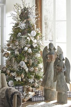 a christmas tree decorated with angel figurines and ornaments