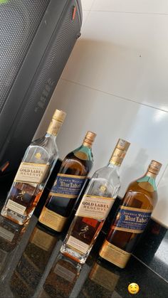 three bottles of whisky sitting on top of a counter