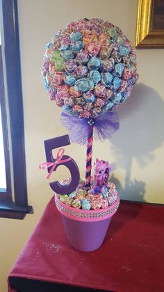 a birthday cake made to look like a candy tree with the number five on it