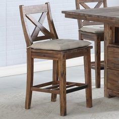 a wooden table with two chairs next to it and a white brick wall in the background